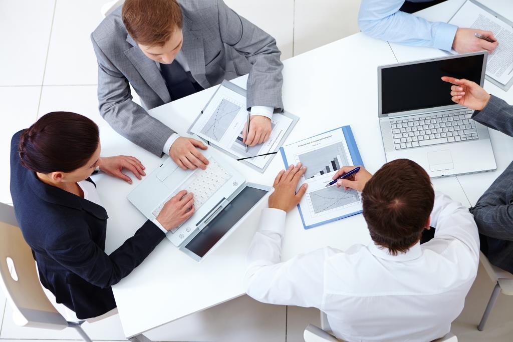 Above view of business team sitting around table and working